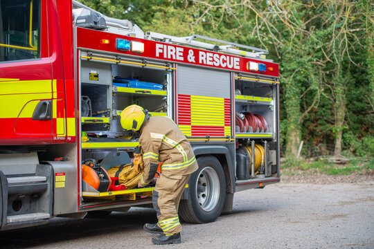 Emergency firefighter taking equipment from a fire engine