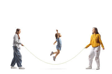 Little girl playing skipping rope with teenage girls