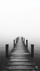 Obraz premium Misty wooden pier extending into foggy lake horizon