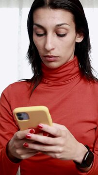 Young woman engaging with smartphone while relaxing at home