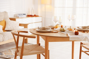 Stylish table setting with beautiful dishware and autumn decor in dining room