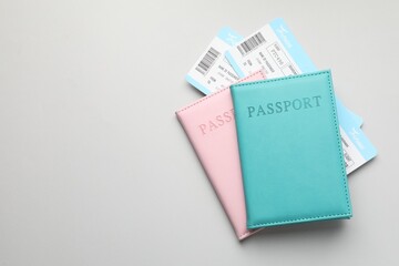 Travel agency. Flight tickets and passports on grey background, top view. Space for text
