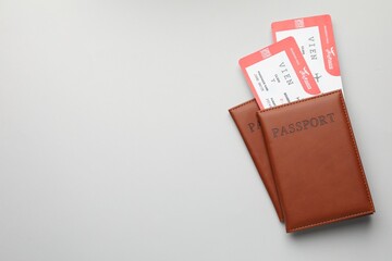 Travel agency. Flight tickets and passports on grey background, top view. Space for text
