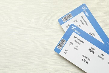 Travel agency. Flight tickets on light wooden table, top view. Space for text