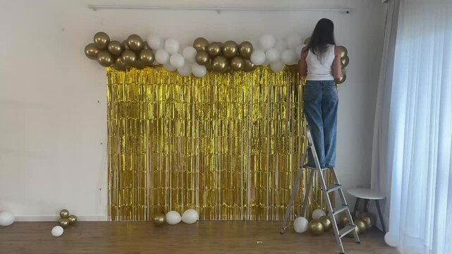 mulher prepara decora&ccedil;&atilde;o para ano novo dourado 