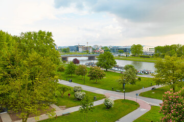 A cozy European park in the center of Krakow. Tourists walk and enjoy a summer evening in a lush park in Poland.