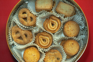 various kinds of cakes in a round container on a red background