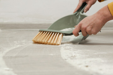 Woman sweeping the floor after renovation 