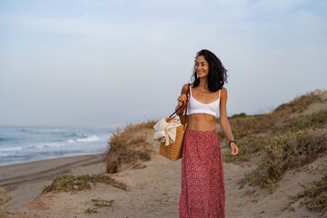 Young Woman Walking on a Sandy Path by the Beach