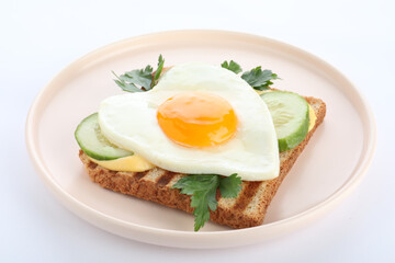 Plate of tasty sandwich with heart shaped fried egg isolated on white