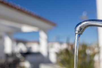 Flowing water from outdoor metal faucet