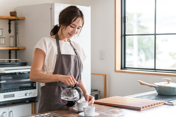 キッチン・カフェでコーヒーをいれる女性  © buritora