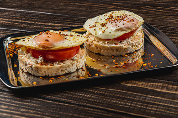 egg sandwiches on rice bread with tomato and cheese on a metal plate