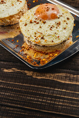 Sandwiches with egg on rice bread with tomato on a plate on a wooden background