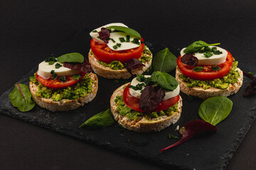 Vegan food concept, rice cakes with fresh vegetables on black background