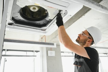 Happy Male Technician Repairing Air Conditioner