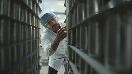 Production control supervisor inspects and controls the operation of each step in the production line of a canned fish factory