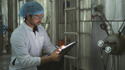 The production control supervisor inspects and controls the operation of machines in the manufacturing line of a canned fish industry