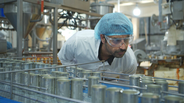 Production control supervisor inspects and controls the operation of each step in the production line of a canned fish factory - Powered by Adobe