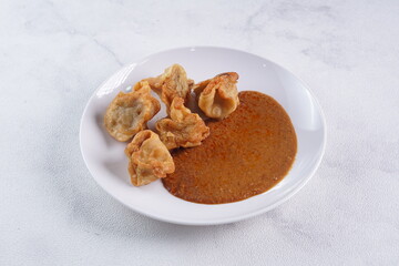 batagor,is a street food that is very popular in Indonesia.made from fish, tapioca and seasoning wrapped in dumplings then fried. Served with spicy peanut sauce. photographed with studio light