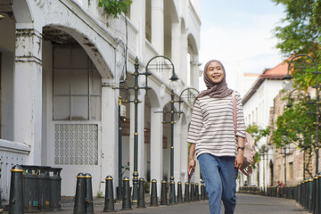 asian muslim woman walking on the street