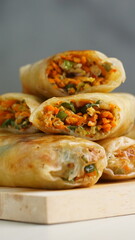 Lumpia or Lunpia, is a traditional snack from central java Indonesia consists of bamboo shoots eggs and meat or shrimp, photographed with wood theme props, studio lighting