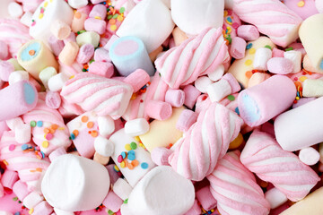 Confectionery and sweeties varieties background: light pink and white marshmallows, sugar confetti, bonbon and candies, selective focus, shallow focus