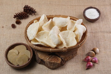 Traditional Indonesian kerupuk snacks, made from catfish, served in a wooden place on a white table with a studio lighting
