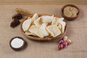 Traditional Indonesian kerupuk snacks, made from catfish, served in a wooden place on a white table with a studio lighting