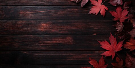 Autumnal red maple leaves on dark wood background.