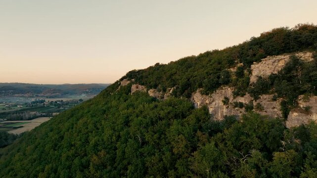 Drone backtracking along a cliff with a medieval village in the background, Beynac and Castelnaud la Chapelle in Dordogne