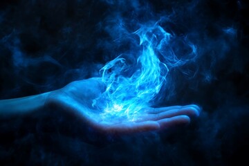 Close up of human hand holding blue fire on dark background