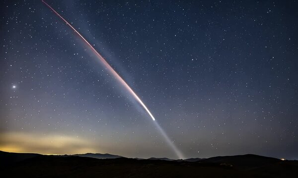 A slow-motion shot of a comet streaking across the night sky, leaving a bright trail as it moves past distant stars in the deep expanse of space