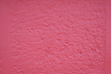 This wall features a textured pink color with a rough and unique surface