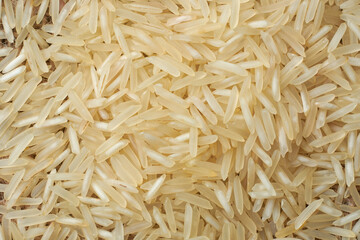 close-up macro view of raw basmati rice grains, pile of creamy white color grainy background in full frame, food wallpaper or backdrop
