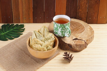 Crispy and savory spinach chips. Made from spinach leaves and rice flour, in a wooden bowl, with wood properties, and studio lighting