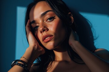 Fototapeta premium Elegant Woman in Blue Light: Perfect for Advertising, Fashion, and Beauty Product Promotion