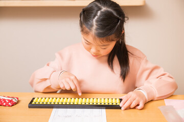 机でそろばん(珠算)をする小学生