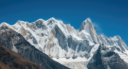 Majestic snow-covered mountain peaks under clear blue sky
