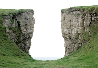 A dramatic coastal landscape featuring two towering cliffs separated by a grassy gap.
