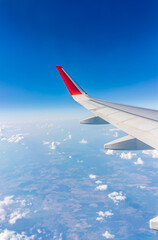 View from the airplane window at a beautiful cloudy sky and the airplane wing