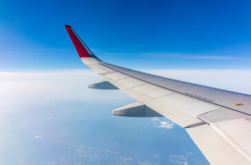 Obraz premium View from the airplane window at a beautiful cloudy sky and the airplane wing