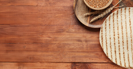 Composition with thin lavash and ears of wheat on wooden background