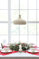 Christmas table setting with fir tree branches near window