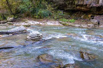 a stream of water in a stone riverbed, spewing noise and rumbling, making its way to free water