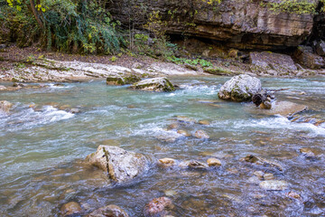 a stream of water in a stone riverbed, spewing noise and rumbling, making its way to free water