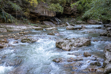 a stream of water in a stone riverbed, spewing noise and rumbling, making its way to free water