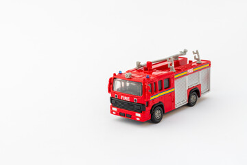 Red fire brigade toy model on white background with space for text.