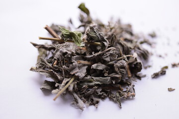 A collection of dry leaves on a clean white surface.