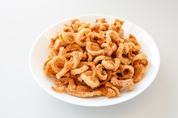 Pork rind, pork cracking,pork snack, in white plate on white background